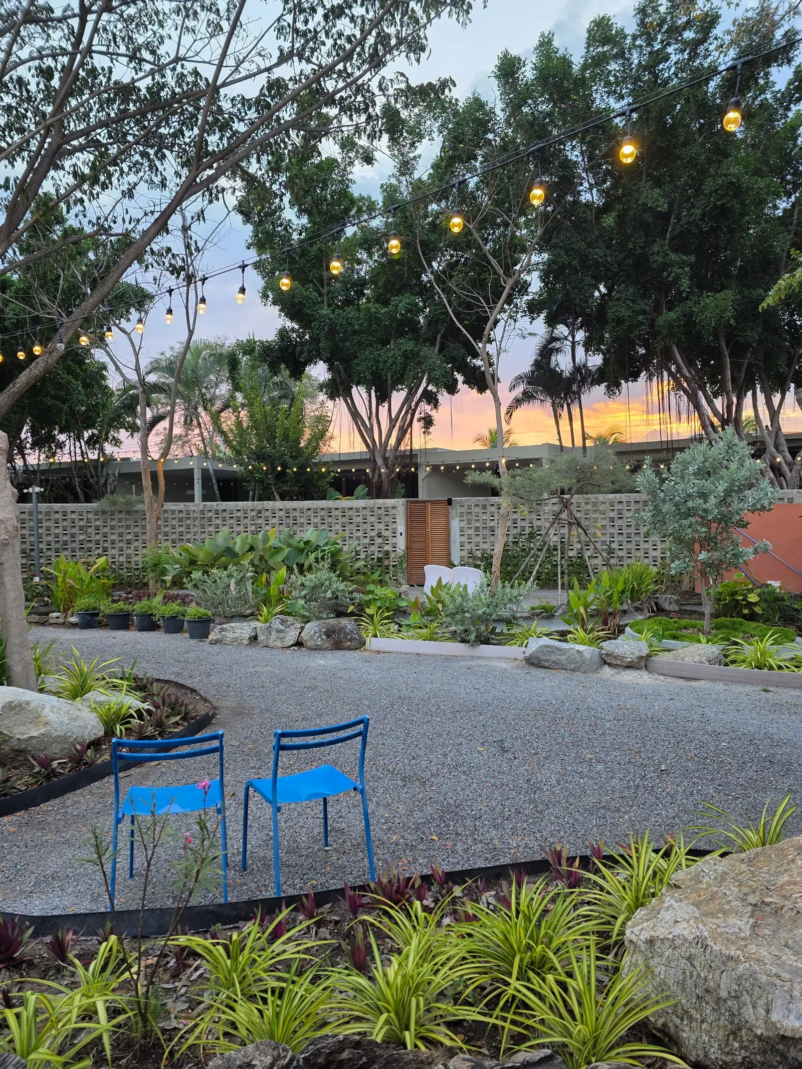 A garden seating area at dusk under string lights